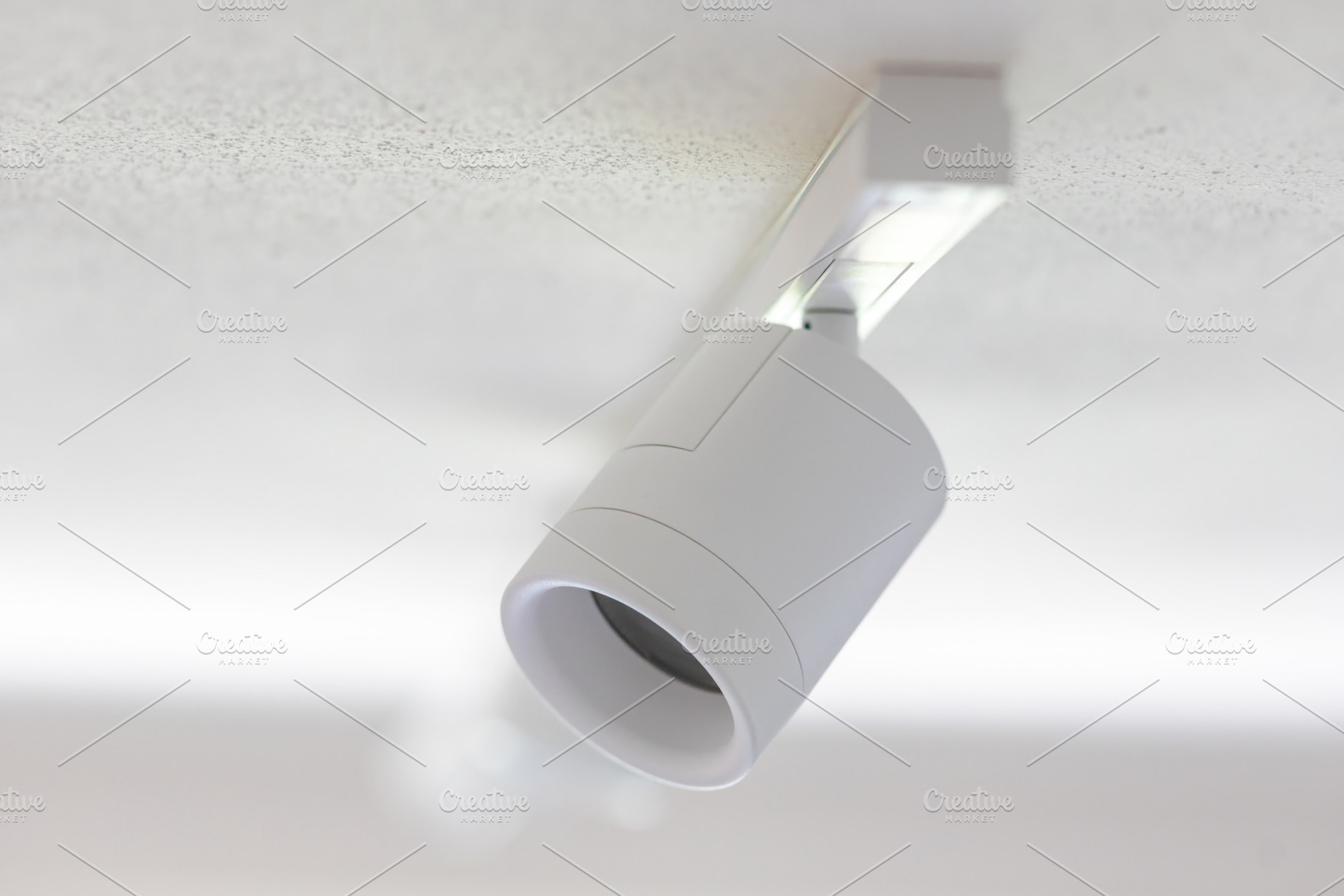 White cylindrical ceiling light illuminating a textured ceiling, an Architecture Photo by Antonio Gravante Market