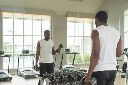 Portrait of strong black african american man using fitness equi, a Photo by Tampatra
