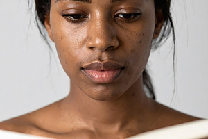 Woman reading book portrait with focused expression, a Person Photo by GoodGoods