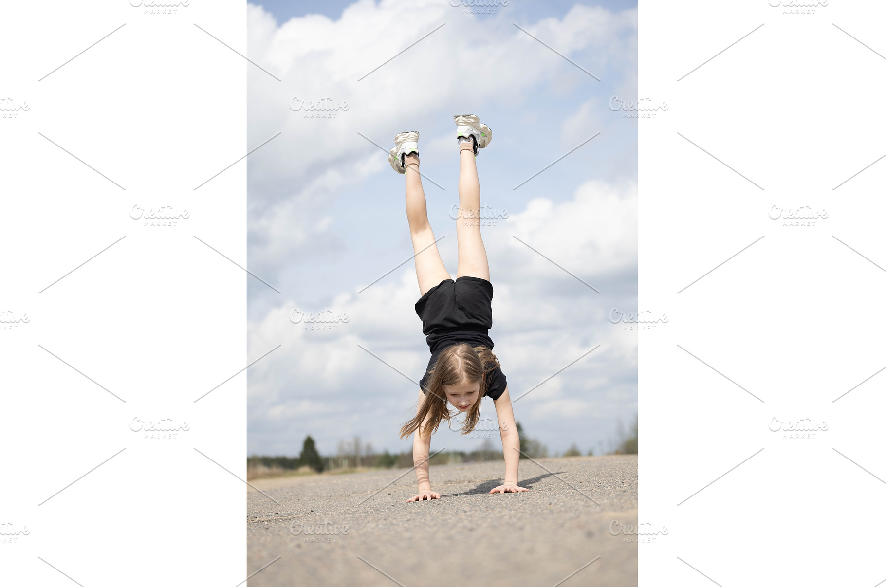 Little girl stands on her hands, a Nature Photo by Nenahliadava Design