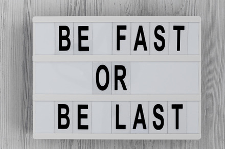 'Be Fast or Be Last' on a lightbox on a white wooden background,, a Business Photo by LiudmylaChuhunova