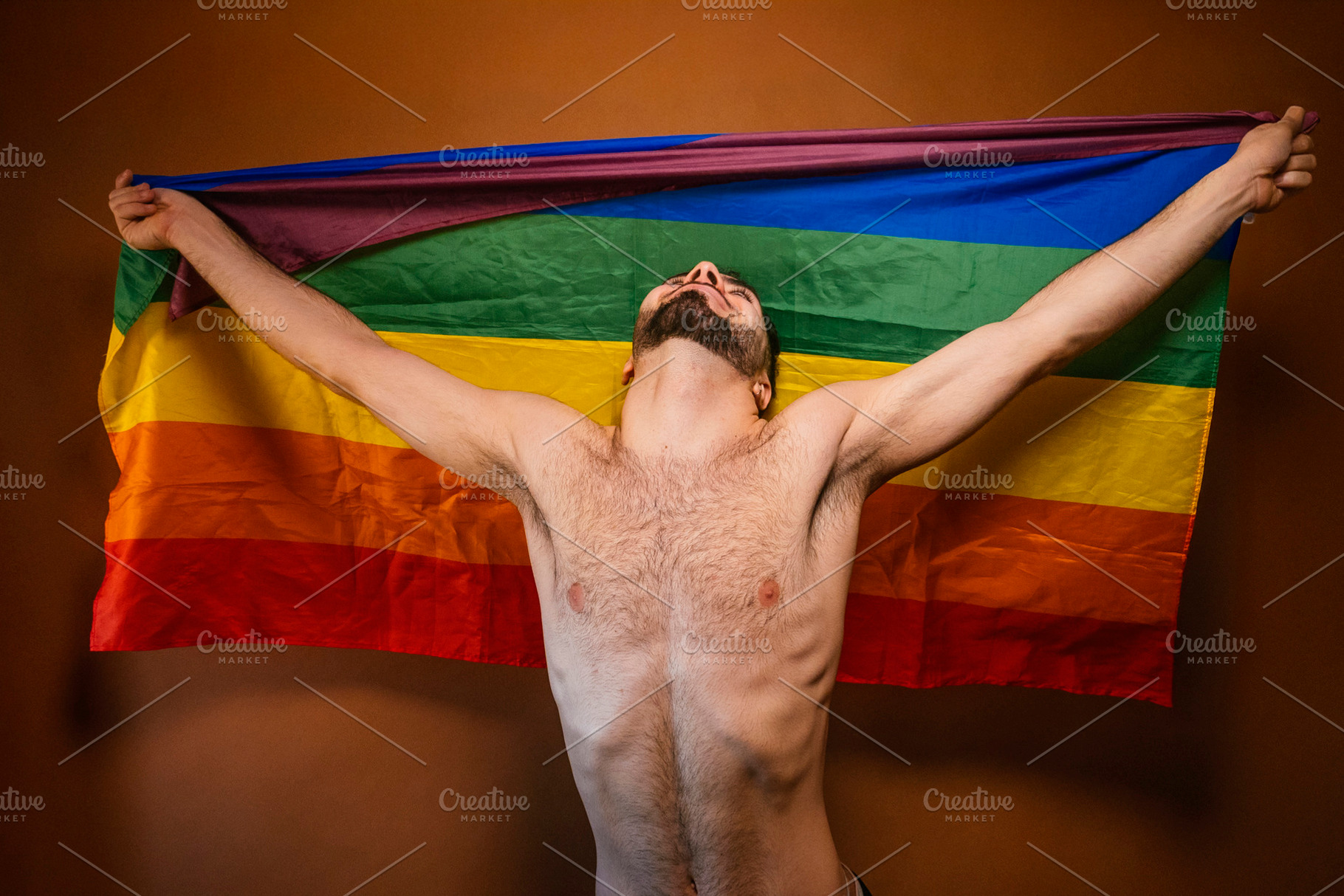 Man raising pride flag celebrating lgbtq+ freedom and identity, a Photo by karrastock
