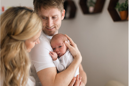 Happy mother and father holding, a Person Photo by HalfPoint