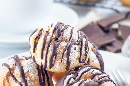 Profiteroles with whipped cream and chocolate filling, covered with melted choc, a Food & Drink Photo by iuliia_n