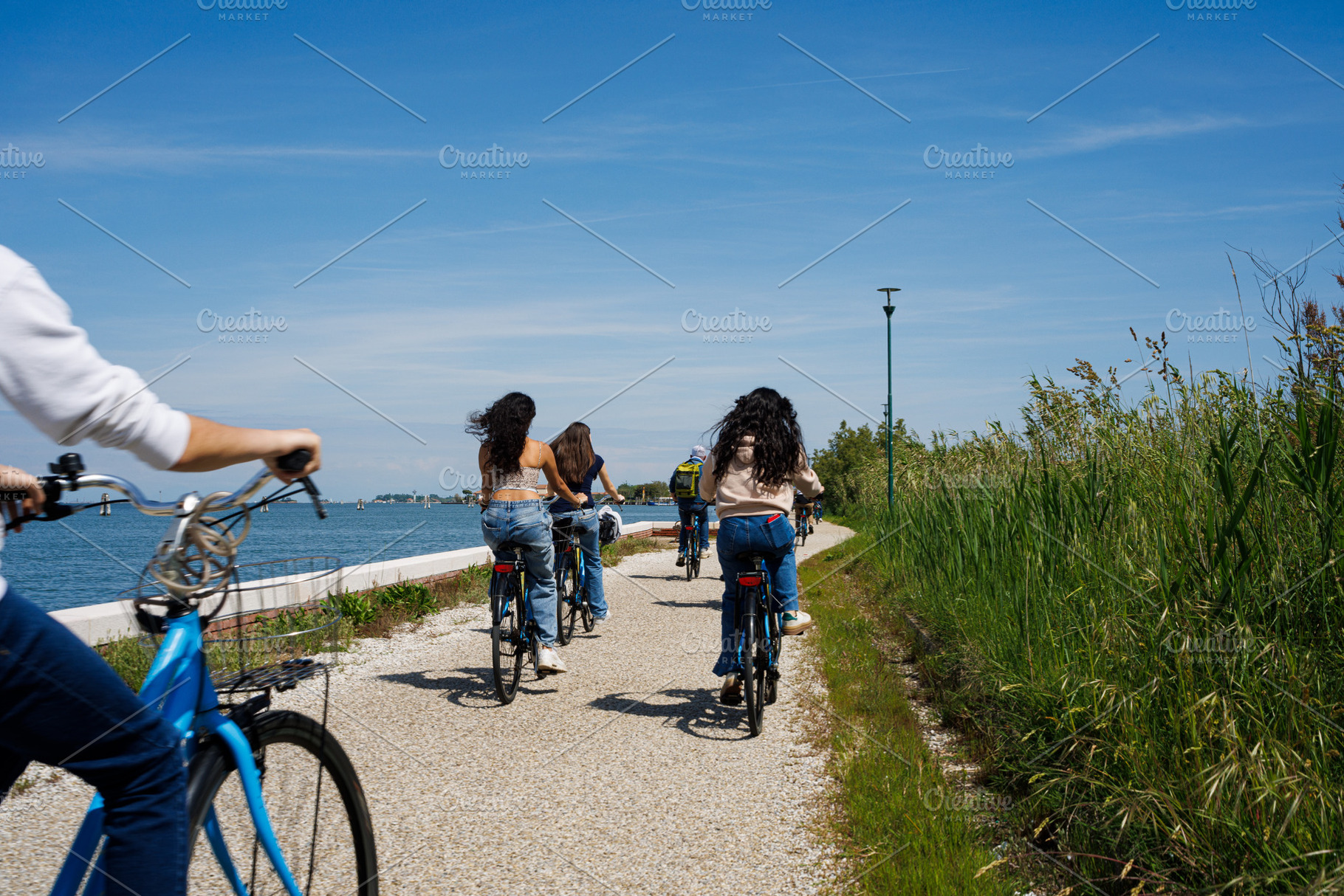 Tourist women riding bike in Pellestrina Island, an Architecture Photo by Bepslabor
