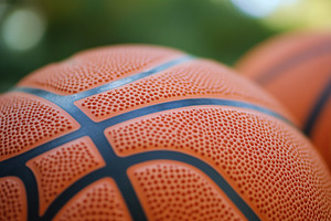 Close view of textured basketballs outdoors during a sunny day in a park settin, a Photo by AlyaAnd