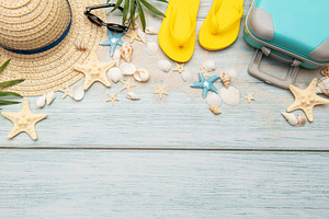 Summer accessories creating a frame on light blue wooden backgro, a Holiday Photo by Olena Rudo