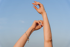 Female Arms and Hands Raised Against Clear Blue Sky, a Person Photo by Red Hot Chili Pepper Shop