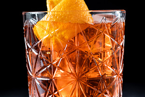 Americano cocktail garnished with twist orange on wooden table, a Food & Drink Photo by etorres69