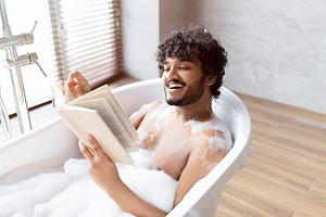 Spa procedure, self care and resting in bathroom. Happy young indian man in bat, a Person Photo by Prostock-Studio