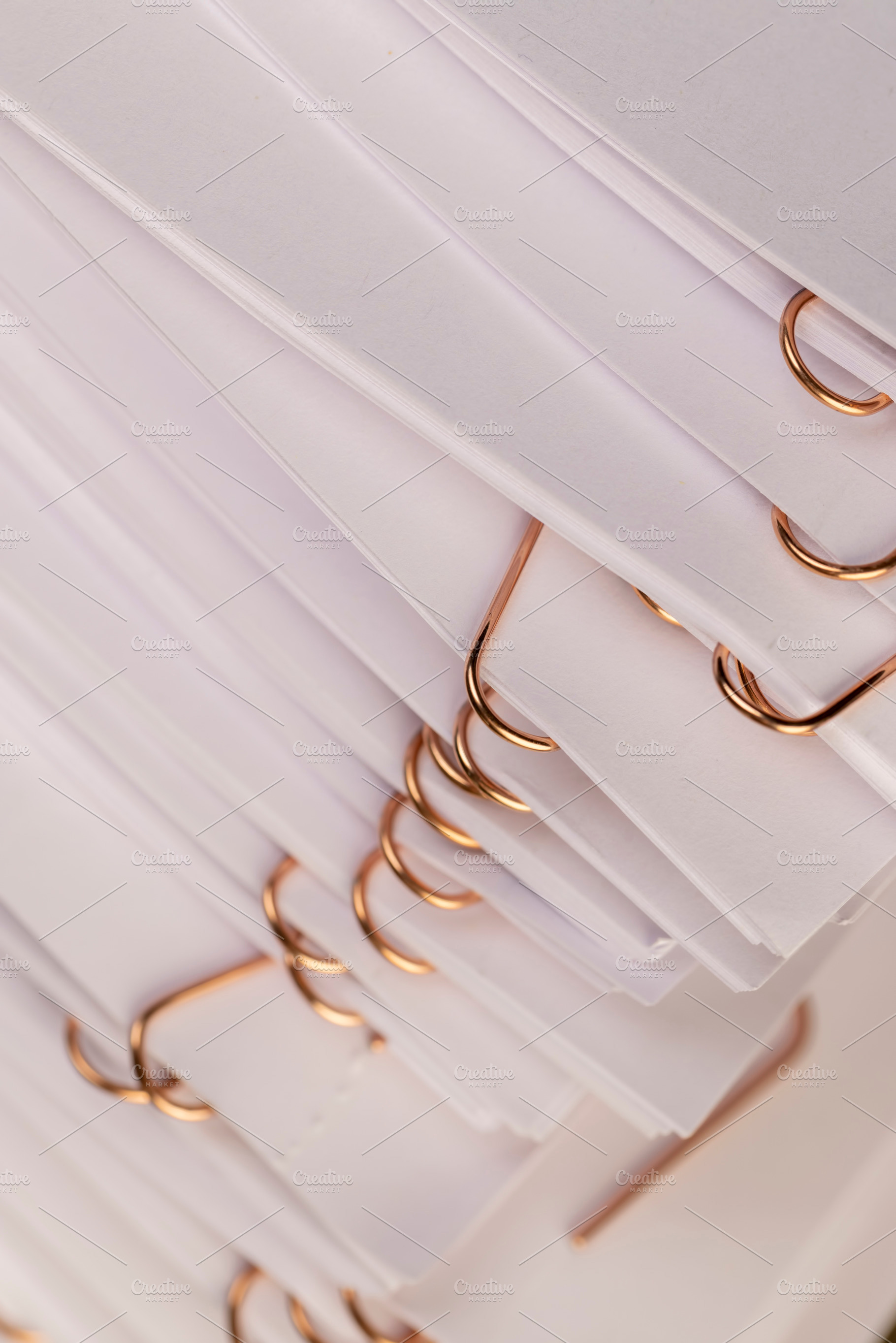 white blank sheets of paper connected by copper staples, a Photo by rsoollAI
