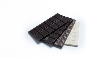 Assortment of white, milk and dark chocolate pieces isolated on white backgroun, a Food & Drink Photo by etorres69
