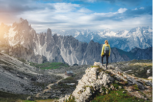 Young woman with backpack on a rock, a Person Photo by den-belitsky