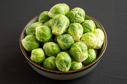 Raw Organic Brussel Sprouts in a Bowl on a black background, sid, a Food & Drink Photo by LiudmylaChuhunova