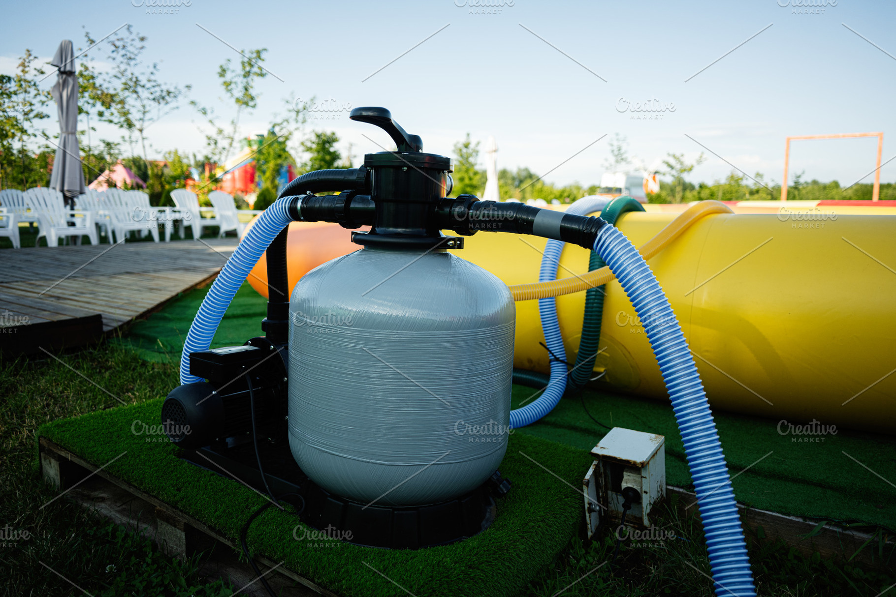 Outdoor pool equipment setup with filtration system and colorful inflatables, a Photo by AS photostudio