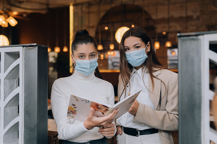 Two girls at the entrance to the building are checking people