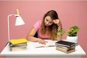 Young woman studying at desk with, a School & Education Photo by volodymyrshtun13795