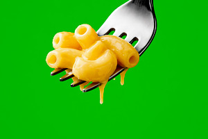mac and cheese on a fork over green, generative AI, a Photo by Nito