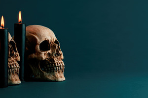 Halloween skull with black candles on dark teal background, a Person Photo by José Manuel Gelpi