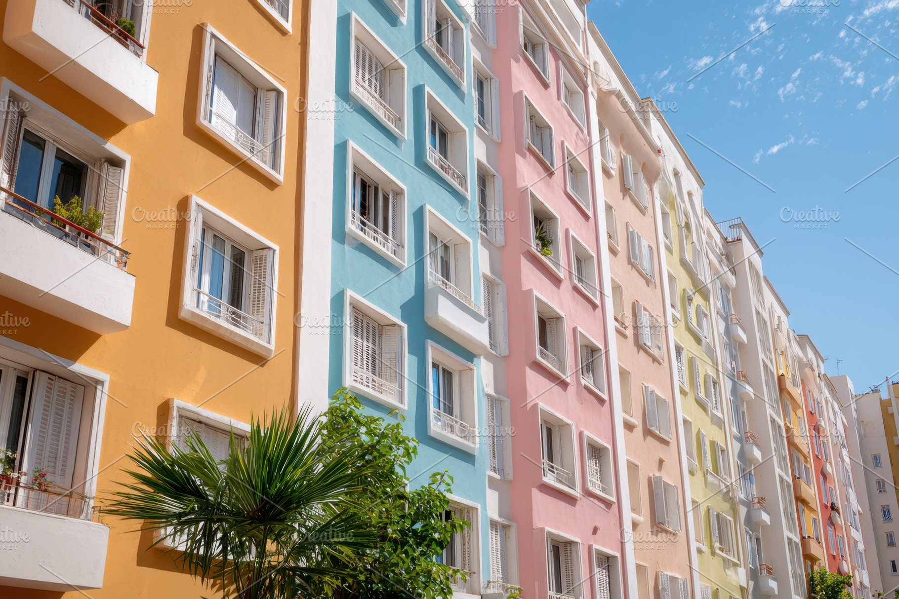 Colorful apartment buildings under blue sky, an Architecture Photo by AlyaAnd
