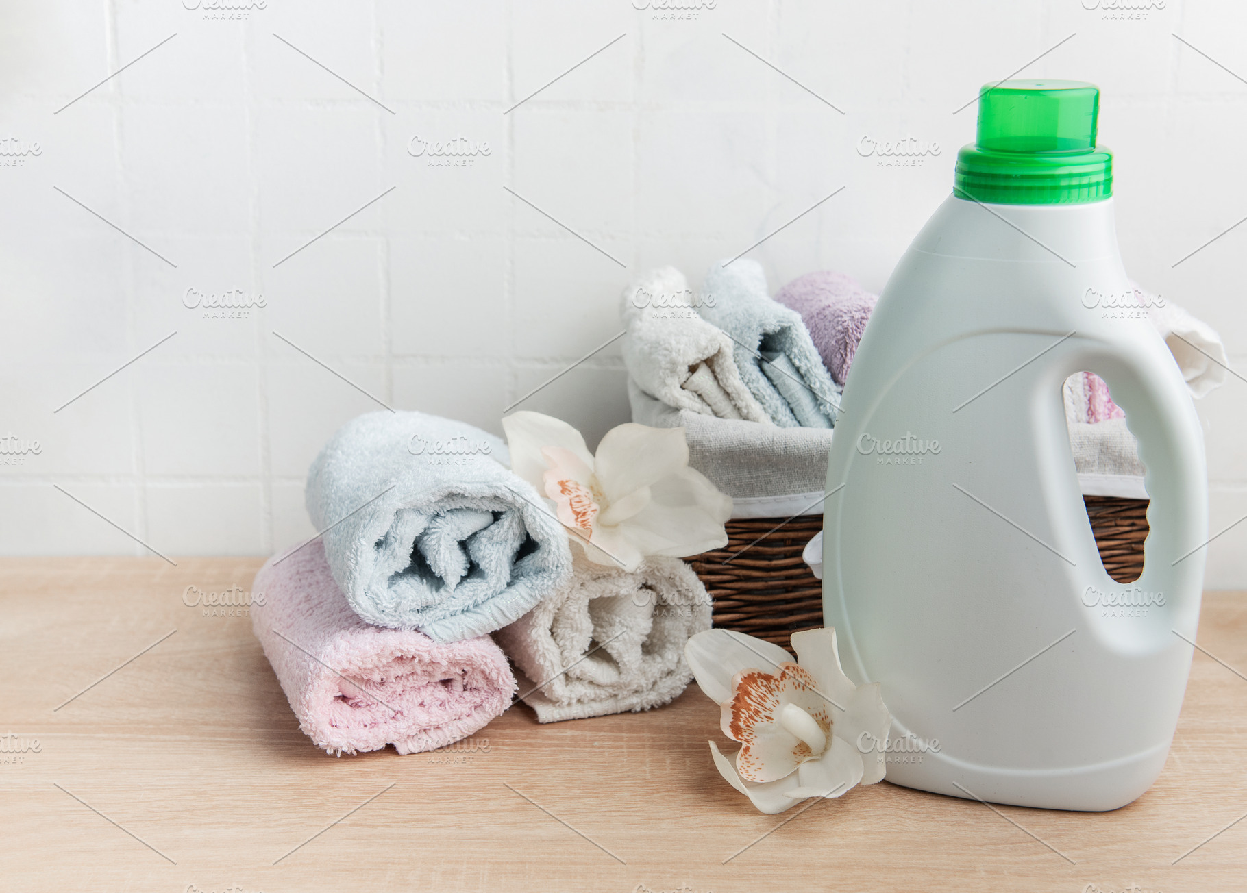 Laundry detergent bottle with fresh clean towels and orchids, an Industrial Photo by Olena Rudo