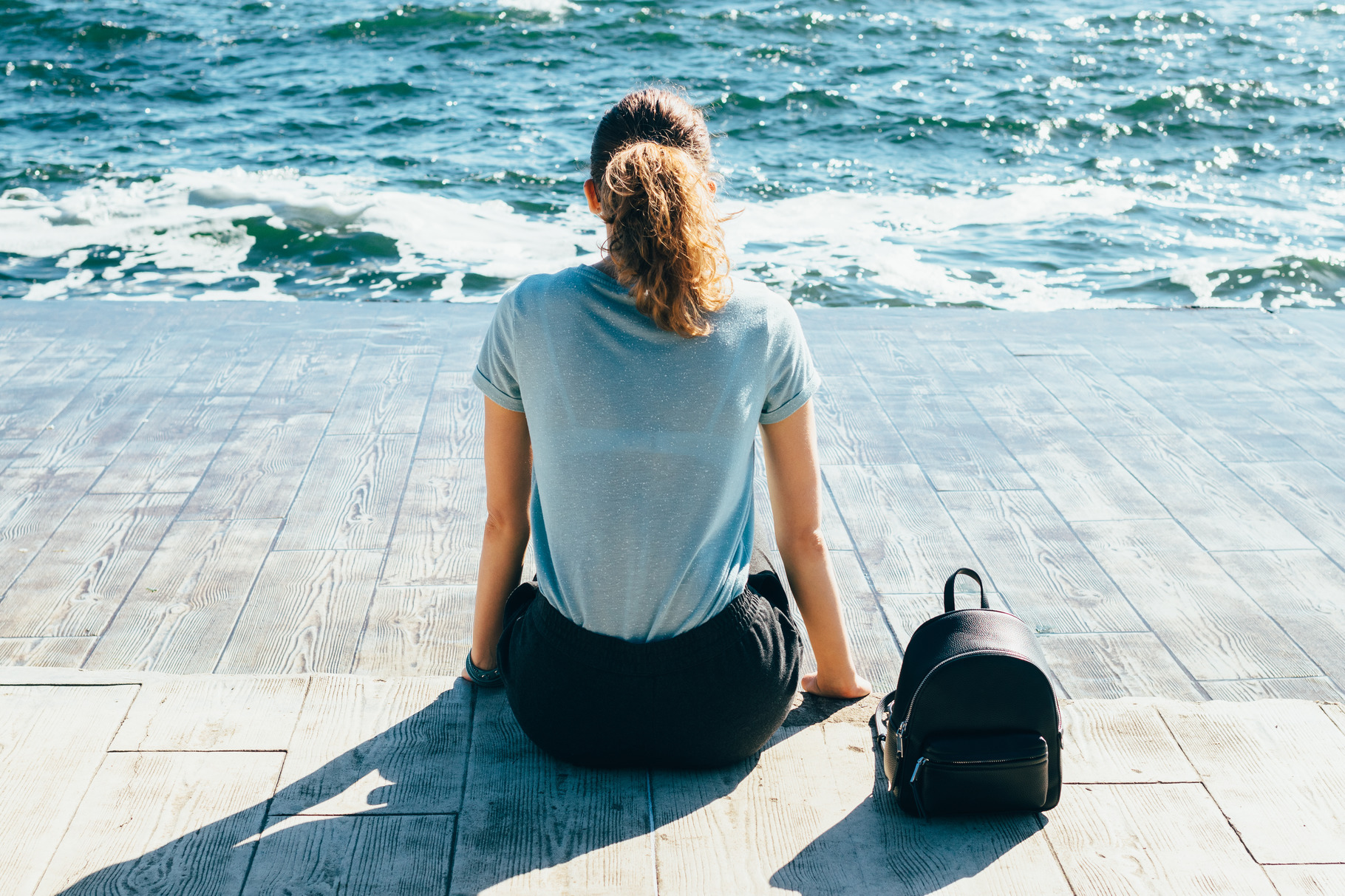 Back view young woman sitting on emb featuring adventure, alone, and ...
