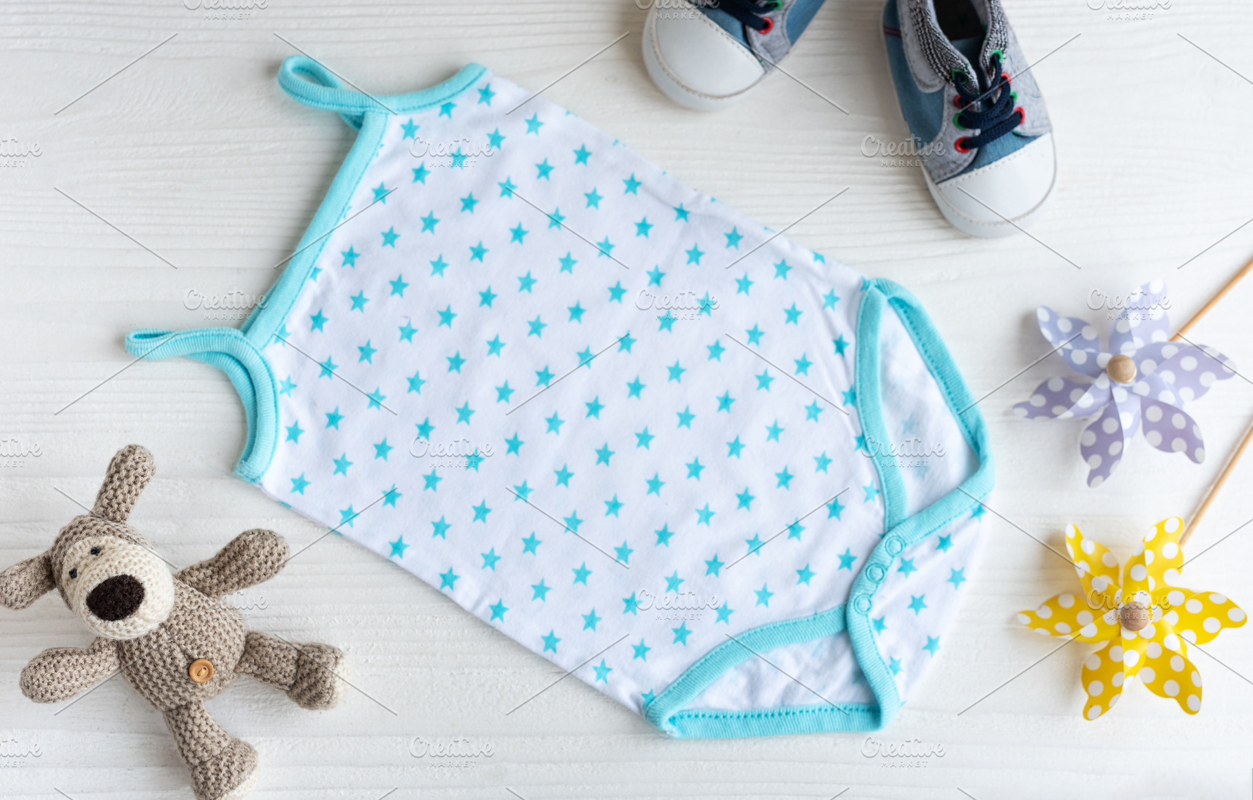 Blue romper  with knittes toy dog, toy windmills  and baby shoes, a Beauty & Fashion Photo by Olena Rudo