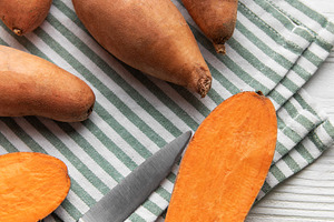 Cutting sweet potatoes for healthy plant based cooking, a Food & Drink Photo by Olena Rudo
