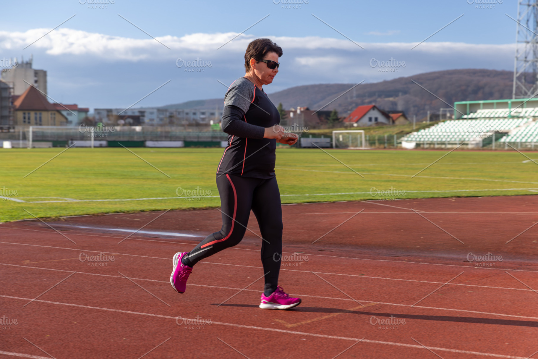 Senior woman running on stadium track, a Photo by Grafvision photography