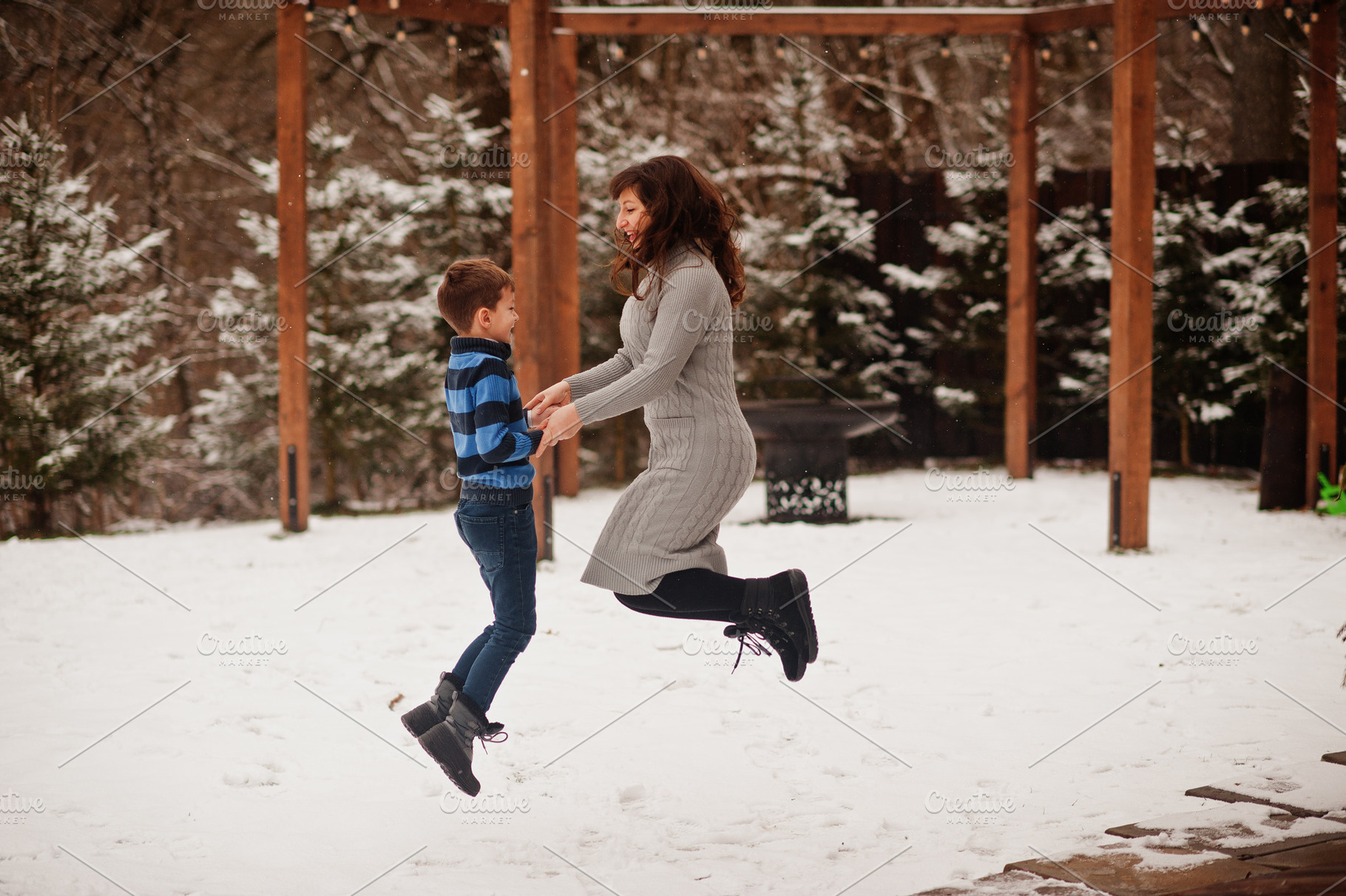 Mother with son jumping in winter day, spending time together., a Person Photo by AS photostudio