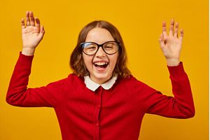 Girl wearing glasses celebrates, a School & Education Photo by IlliaBondarPhotography