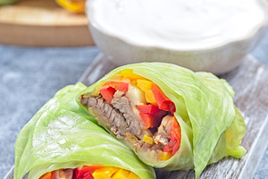Closeup cut of beef and vegetable cabbage leaves wraps, served with plain yogur, a Food & Drink Photo by iuliia_n