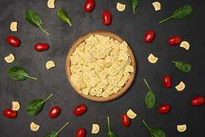 Uncooked tortellini pasta with fresh cherry tomatoes and spinach, a Food & Drink Photo by ndanko