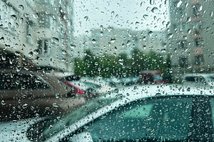Raindrops on a window with a view of parked cars on a rainy day, a Photo by AS photostudio