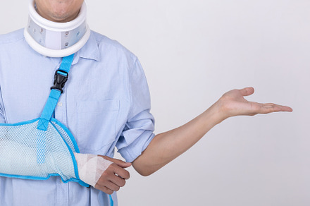 Asian man with broken arm and neck showing empty space isolated