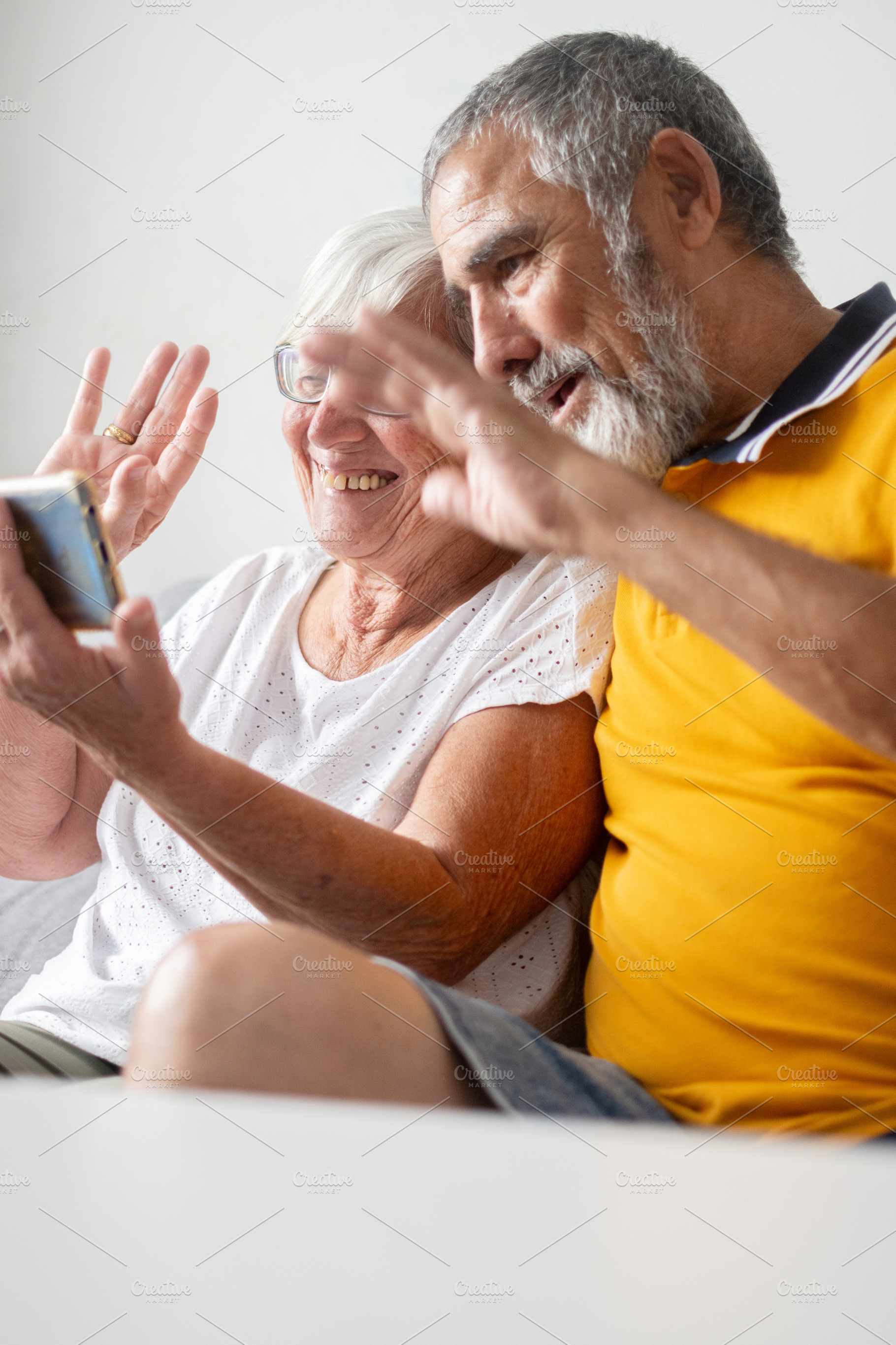 Senior couple waving during video call, a Person Photo by etorres69