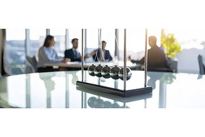 A Newton’s cradle in focus with, a Business Photo by Igor Tichonow