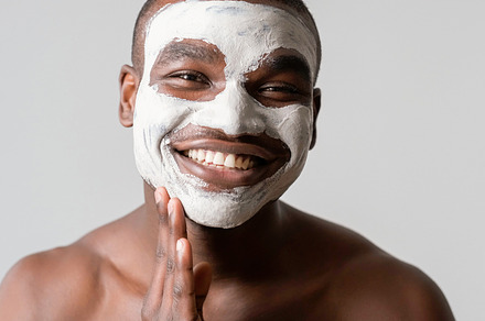 Man cosmetic facial mask applying cleaning clay, a Photo by Photo Drive Studio