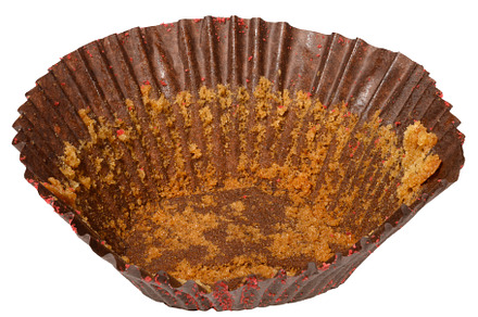 Empty brown paper cupcake or muffin tin with chocolate residue,