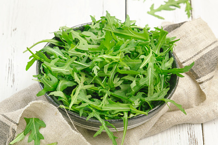 Fresh green arugula in rustic ceramic bowl on white kitchen tabl, a Food & Drink Photo by 5PH