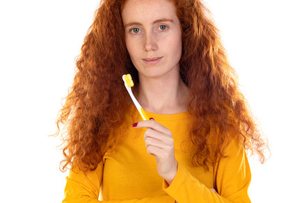 Attractive smiling girl happily looking in camera brushing teeth, a Person Photo by José Manuel Gelpi