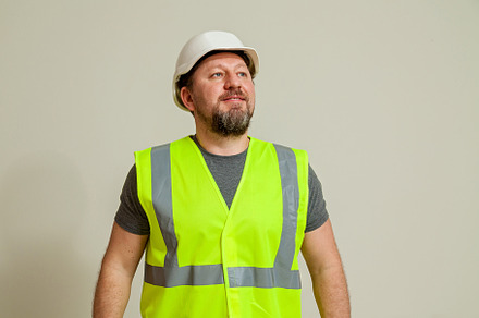 worker in a vest and white helmet, a Person Photo by Photostock