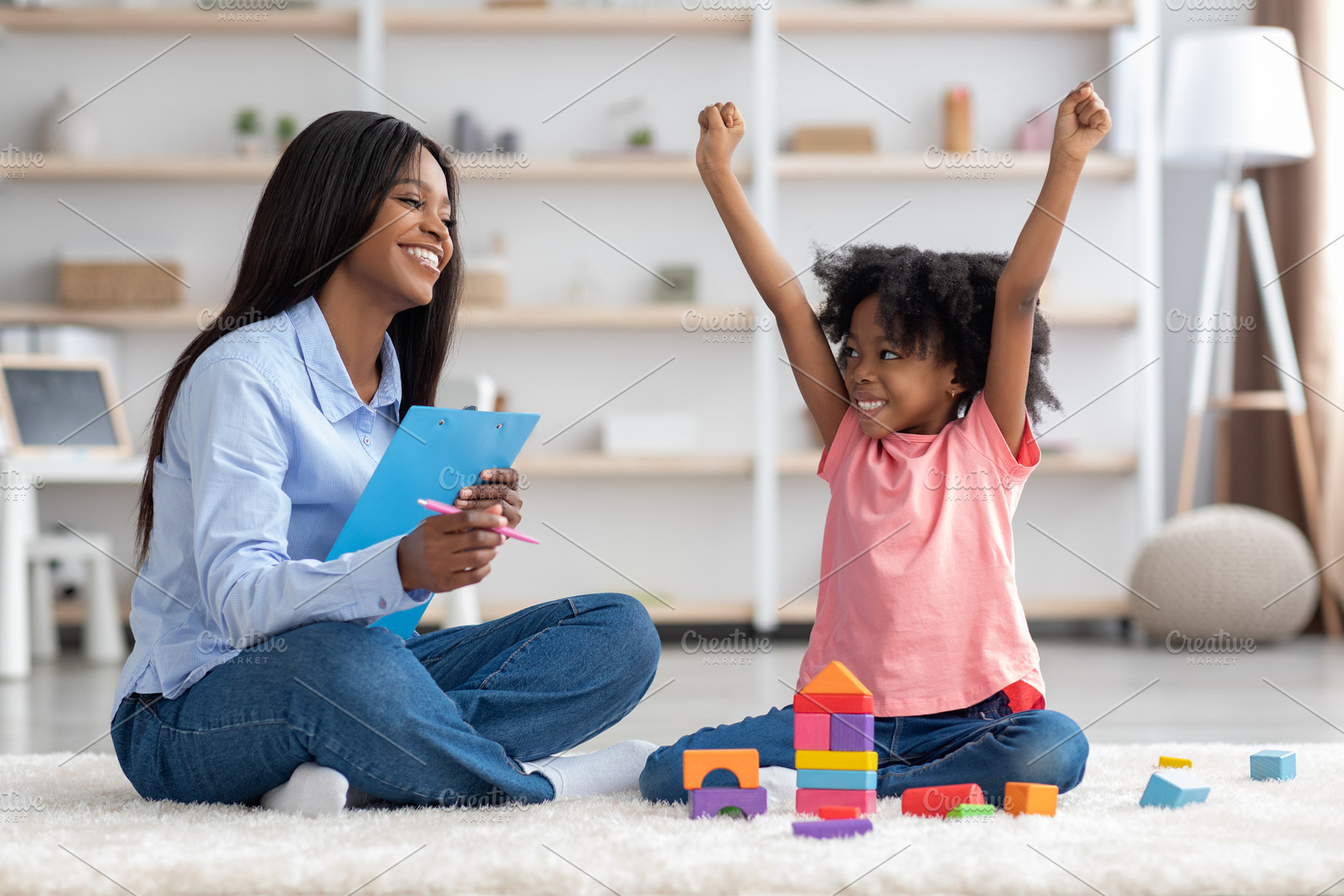 Emotional little girl raising hands up, having session with psychologist, a Photo by Prostock-Studio