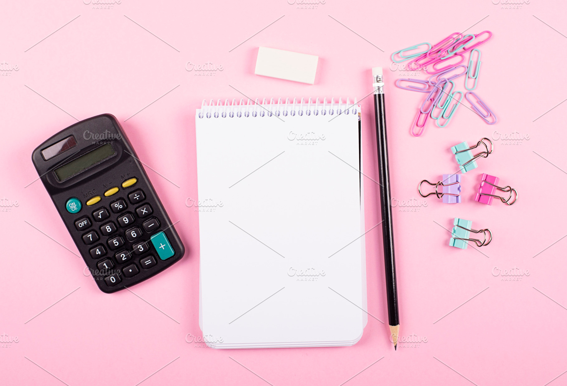 Notebook next to clips calculator, and pencil on pink background. Back to school concept., a School & Education Photo by José Luis Agudo