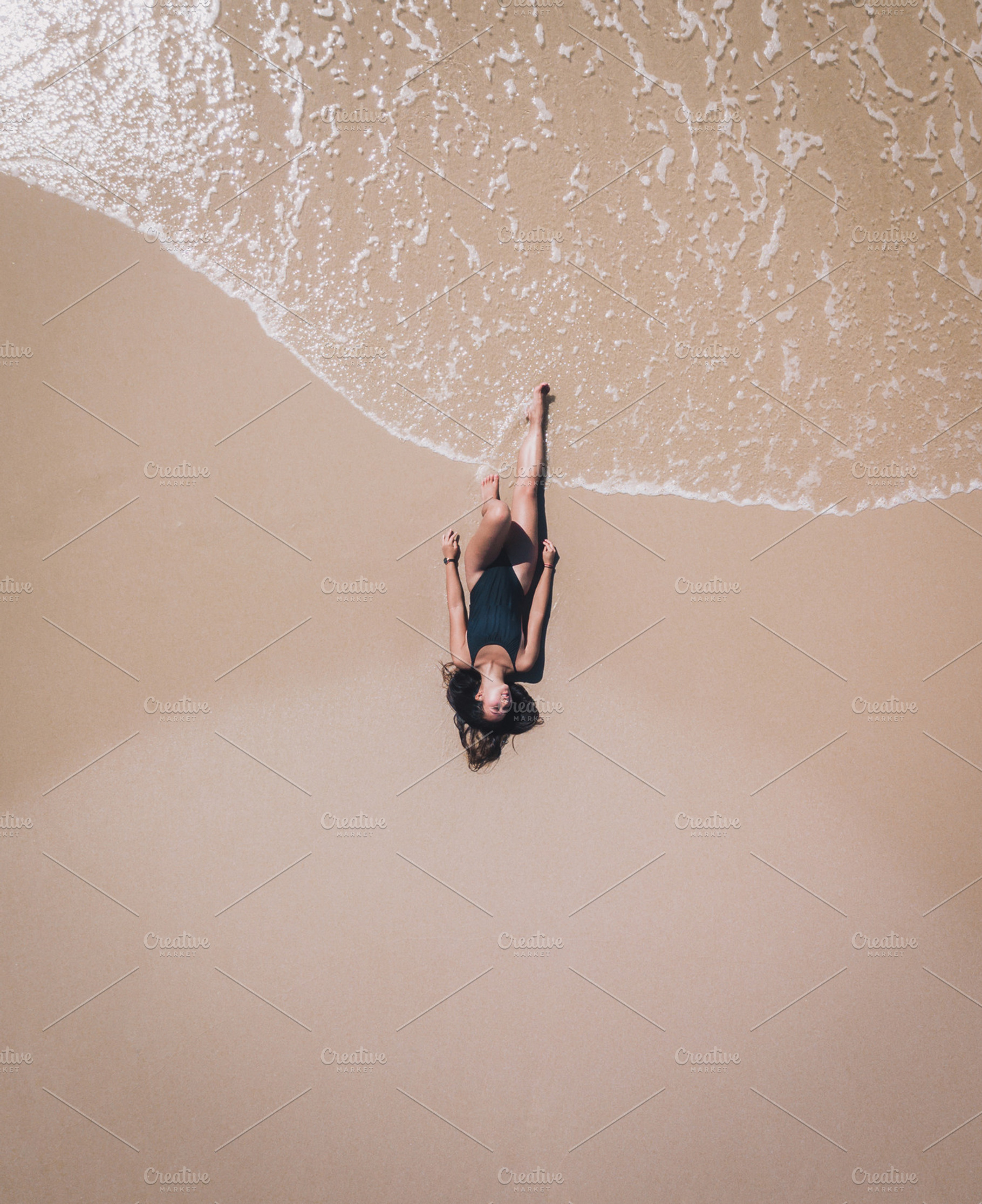Aerial of Girl tanning on beach, a Person Photo by Chris Joel Campbell
