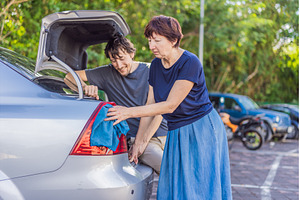 Older woman washing a car together, a Person Photo by Elizaveta Galitskaya