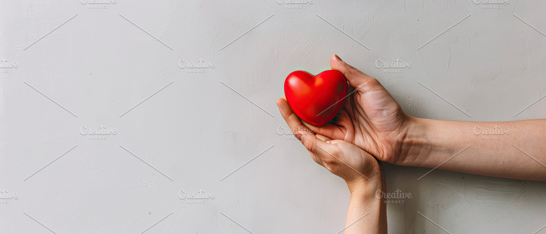 Female's hand holding red heart agai, a Photo by LOGOCREATIVE