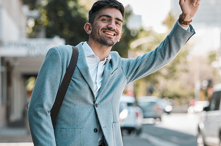Business man, wave and taxi in traffic, street or city for transportation, travel and smile in finance career. Young accountant, happy and outdoor on sidewalk to stop bus, tram or car in metro road, a Photo by Peopleimages.com