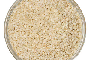 White sesame seeds in a round glass bowl on an isolated backgrou, a Food & Drink Photo by ndanko