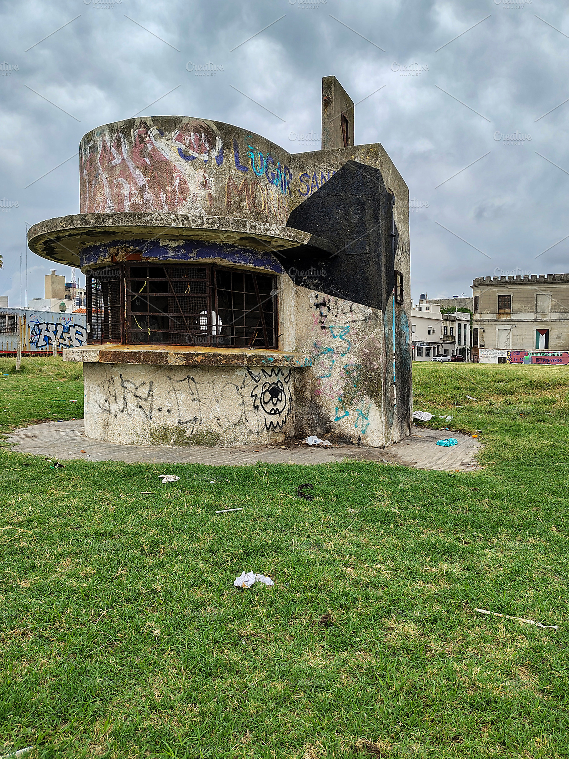 An abandoned police booth stands alone in an overgrown grassy ar, an Architecture Photo by DanFLCreativo